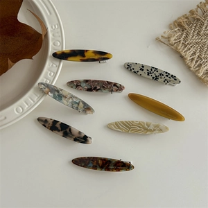 Set of 8 French acetate hair clips in leopard and marble patterns on white plate