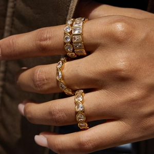 Close-up of four 18K gold plated stainless steel rings with sparkling cubic zirconia stones