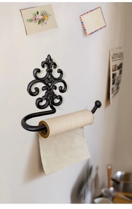 Detail of vintage black cast iron toilet paper holder with decorative scroll design