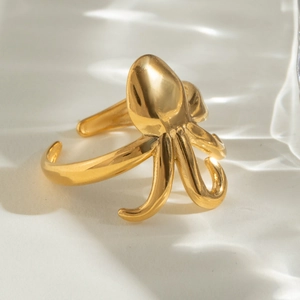 Dettaglio dell'anello a forma di polpo dorato con riflesso creativo di onde marine