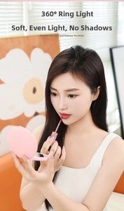 Close-up of a portable pink LED makeup mirror showing the 360 ring light effect on a model
