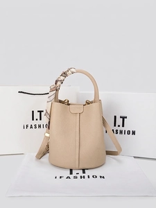 Elegant beige leather bucket bag with silk scarf handle and adjustable shoulder strap