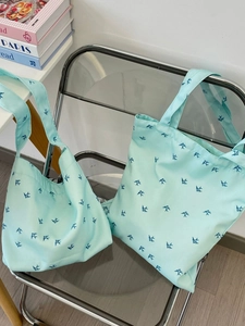 Light blue canvas tote bag set with navy blue swallow prints in a minimalist style