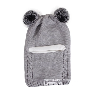 Close-up of grey knitted winter hat for children featuring dual black faux fur pom-poms