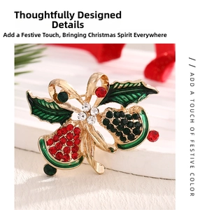 Detailed close-up of a Christmas bell brooch with red and green rhinestones on stone base