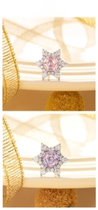 Close-up of star-shaped zircon earrings with pink and purple hexagonal center stones