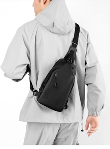 Rear view of model wearing a black waterproof crossbody bag with adjustable strap