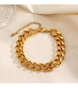 Detail of gold Cuban link bracelet in stainless steel with lobster clasp and silk background