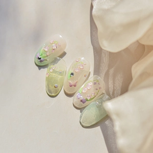 Close-up of pink lily of the valley nail stickers with pearls and rhinestone accents