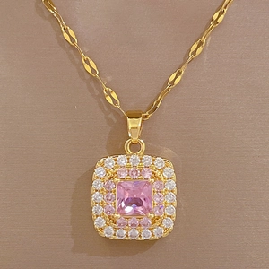 Detail of gold square pendant featuring a pink center stone and crystal border