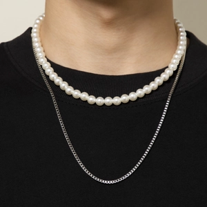 Hip hop layered necklace with geometric box chain and faux pearls on black sweatshirt