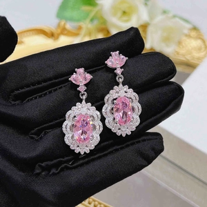 Close-up of elegant pink oval earrings with micro-set crystals in a vintage palace style