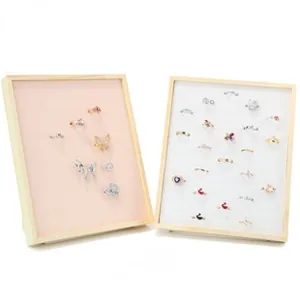 Detail of pink and white microfiber jewelry display stands with wooden frames and rings
