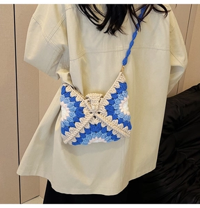 Close-up of handmade sunflower crochet bag with blue and white knit floral patterns