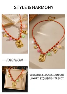 Détail du collier bohème tressé rouge avec breloques coeur et perles élégantes