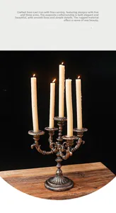 Detailed macro view of vintage 5-head iron candelabra with carved textures and warm candlelight