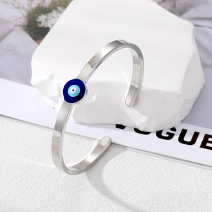 Minimalist silver copper bangle featuring a blue evil eye charm on a white stone base