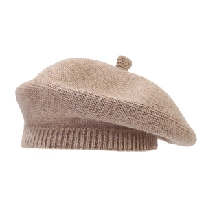 Classic beige knitted beret hat for women with thick warm wool texture in a minimalist style