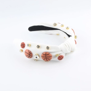 Détail du serre-tête noué blanc avec breloques de basket orange et strass étincelants