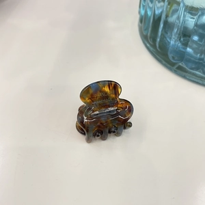 Close-up of a mini amber tortoise shell hair claw clip with France Handmade lettering