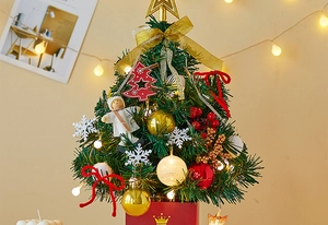 Mini lighted Christmas tree detail with gold ornaments, snowflakes and a red crown base