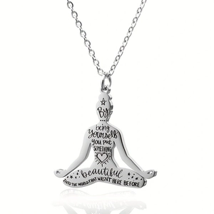 Macro shot of silver stainless steel yoga pendant with inspirational English engraving