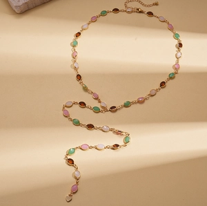 Detailed close-up of golden resin pendant sweater chain with multi-colored oval gemstones