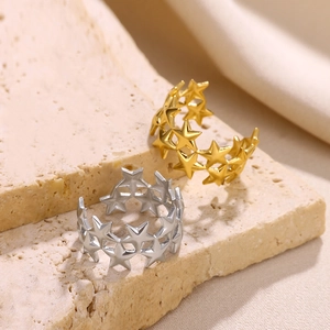 Detailed view of hollow star-shaped open rings in gold and silver plating on stone