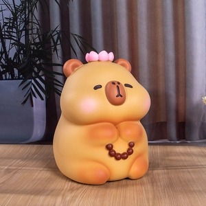 Tirelire Capybara mignonne avec fleur de lotus et perles sur fond en bois