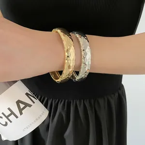 Détail de joncs facettés en or et argent avec des reflets miroirs géométriques élégants
