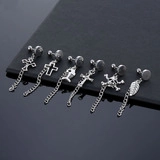Detail showing six punk-style stainless steel hoop earrings with cross and skull pendants