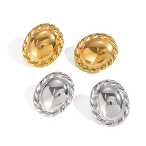 Macro detail of oval hoop earrings in gold and silver finish with textured twisted edges