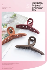 Close-up of matte claw clips in wine red, caramel, and coffee colors for long hair