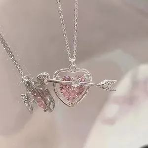 Macro shot of silver cupid's arrow necklace with a pink heart zircon stone detail