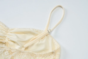 Detail of cream lace top with adjustable straps and high-density floral embroidery