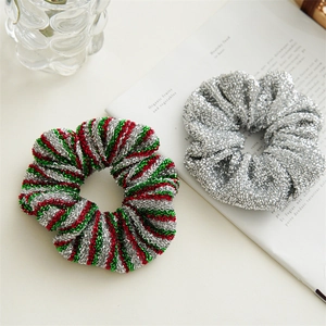 Close-up of sparkling silver and festive red, green, and silver striped hair scrunchies