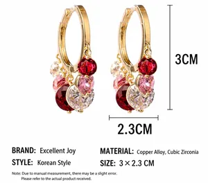 Detail of gold hoop earrings with red, pink, and clear cubic zirconia gemstones