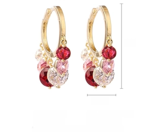 Detail of gold hoop earrings with red, pink, and clear cubic zirconia gemstones