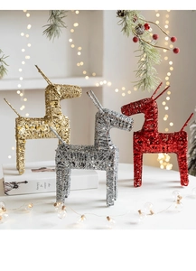 Close-up of three decorative Christmas reindeer in gold, silver, and red with glitter