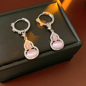 Macro detail of silver gourd earrings with pink cat-eye stone and pavé zircon inlay