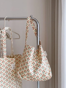 Close-up of quilted floral cotton tote bag with vintage flower patterns and side label