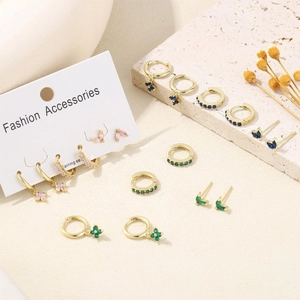 Gold birthstone earring set with butterfly and clover charms on fashion accessory card
