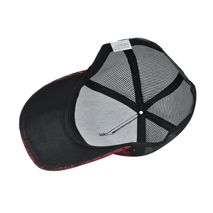 Detail view of the houndstooth trucker cap interior showing the 100% cotton wash label
