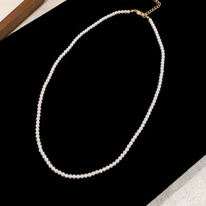 Detailed view of the small white pearl necklace with adjustable gold-tone lobster clasp