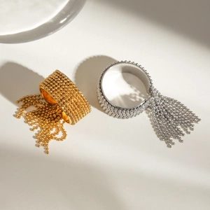 Detailed view of beaded stainless steel rings with fringe tassels in gold and silver finish