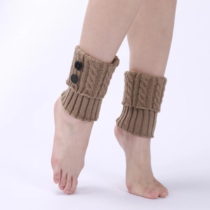Detailed knit texture of brown cable-knit leg warmers with vintage decorative buttons