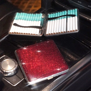 Detail of red rhinestone stainless steel slim cigarette case on a car center console