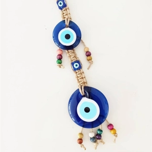 Detail of handmade evil eye wall hanging with woven hemp rope and colorful wooden beads