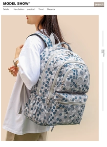 Detail of multi-layer zipper compartments and polka dot pattern on the large backpack