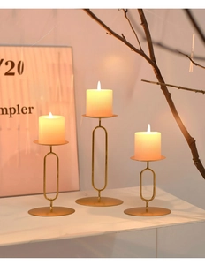 Three-piece gold metal candle holders with LED candles in a warm home setting